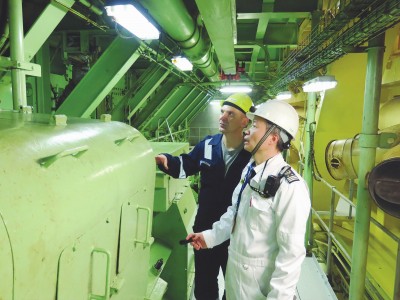 刘良喜(右)正在外轮轮机舱检查设备。本报记者何易摄.jpg