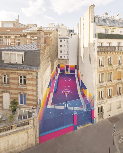 在巴黎两栋老旧的公寓楼之间，有一个篮球场像三明治一样被夹在中间。艺术家把这个球场涂上了彩虹般的色彩，让置身其中的人们仿佛沉浸在夕阳落日的余晖中.jpg