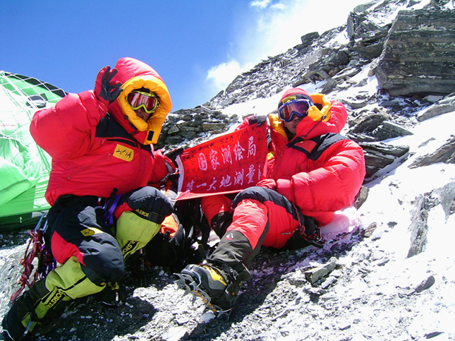 2005年在珠峰复测时，登顶测绘队员柏华岗、任秀波在海拔7790米拉起队旗合影，队旗上有珠峰复测全体人员签名。.JPG