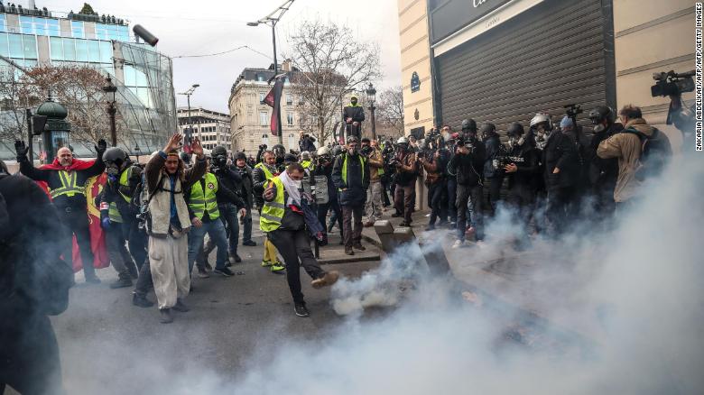 Protesters clash with riot police amid tear gas Saturday on the  Champs-élysées in Paris.