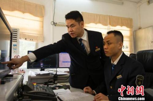 图为罗驰在指导同事工作。　覃建勋 摄