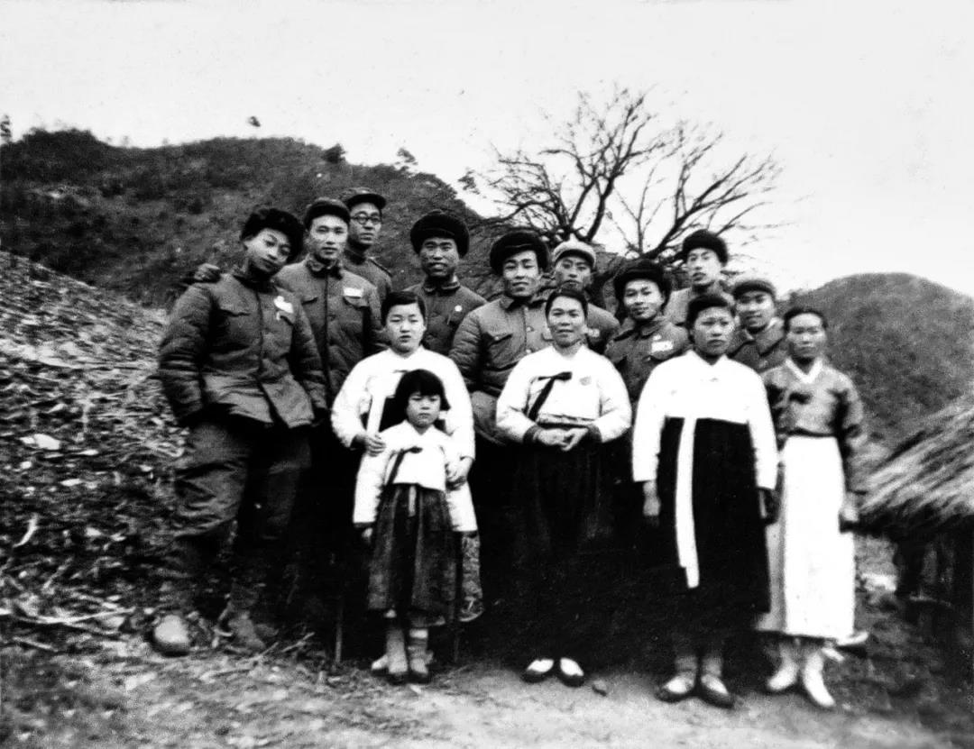 志愿军战士与朝鲜村民合影留念。前排左起为石吉荣、朴大嫂、宋顺女；后排左四为杨彧.jpg