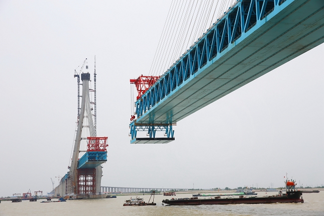2019年5月6日，沪通长江大桥28号墩完成第13轮大节段钢梁双悬臂架设吊装作业。至此，28号主墩钢梁架设长度达到826米，距离南通侧27号辅助墩墩顶钢梁对接只有一“吊”之遥。.jpg