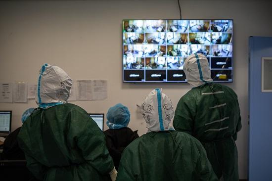 插管前“敢死队”队员监控病房内准备情况。