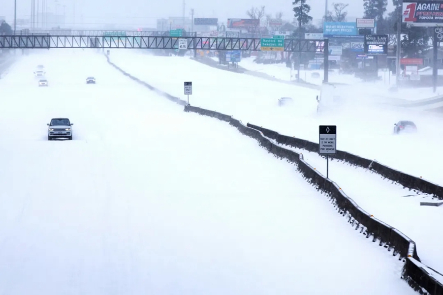 2月15日，汽车行驶在美国得克萨斯州伍德兰兹的雪地里。 本文图片均来自新华社