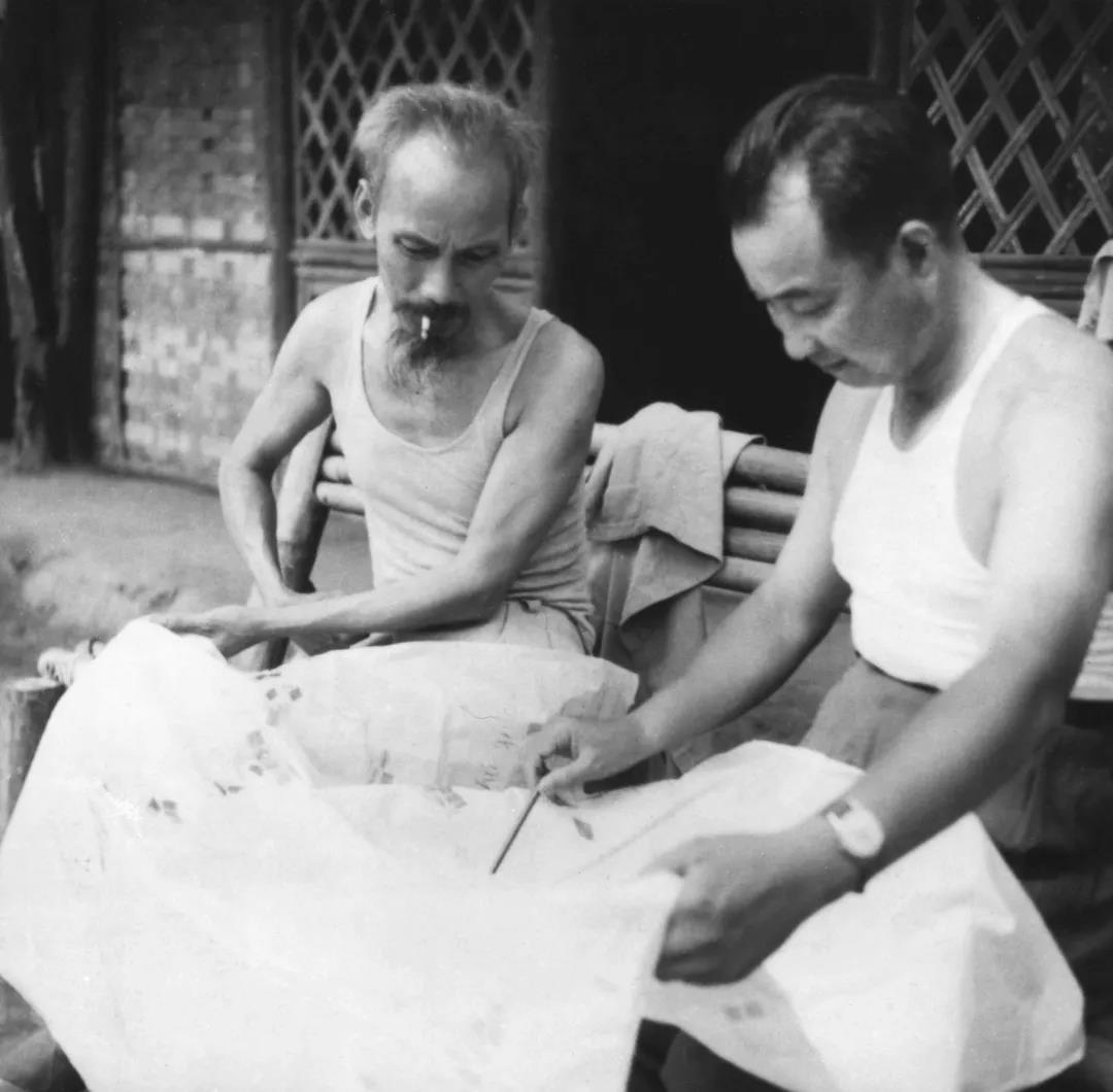 1950年7月18日，陈赓（右）在胡志明主席所住的茅顶高脚屋前与他研究攻打高平的战役.jpg
