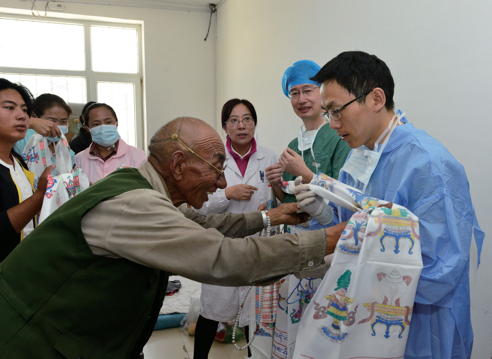 序号7社会参与：“慈善光明行”志愿者医生在青海省果洛藏族自治州久治县义诊，当地群众术后送上哈达表示感谢.jpg