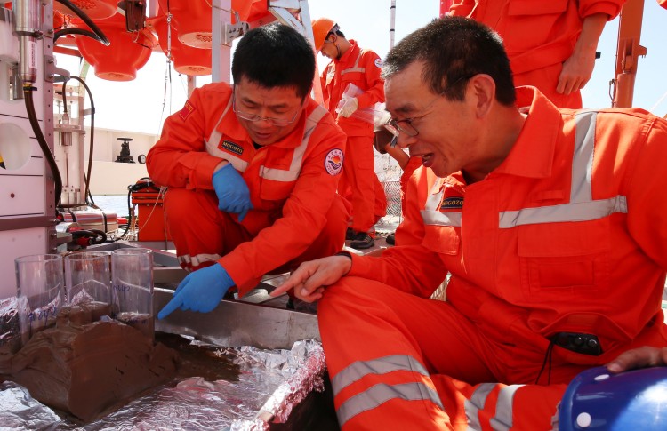2 2016年12月27日，首席科学家许云平（前排左）与海试总指挥崔维成（前排右）讨论2号着陆器获得的马里亚纳海沟海底沉积物样品.jpg