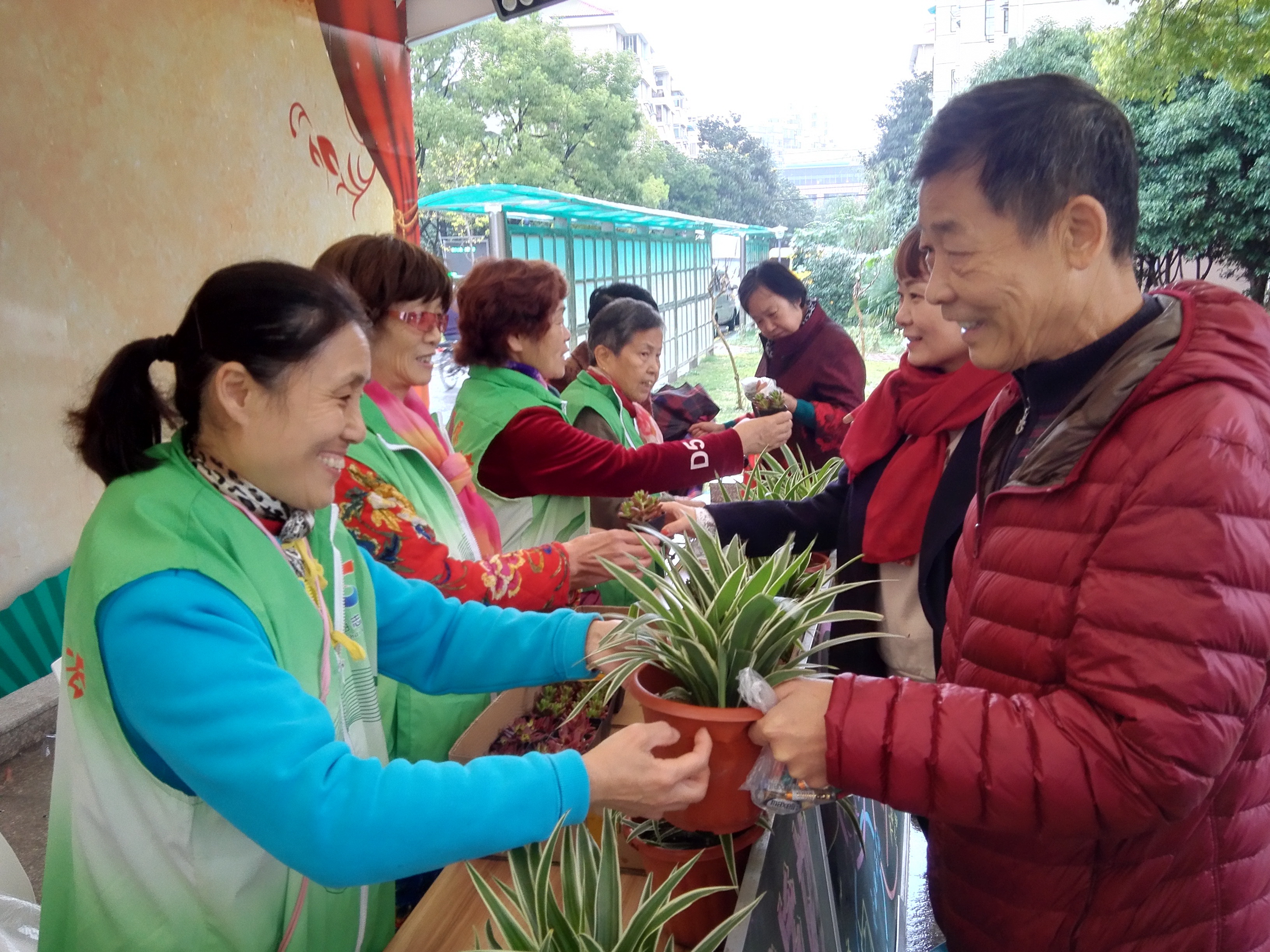 沈秀英(左一)在平吉二村为居民分类有害垃圾兑换绿植.jpg