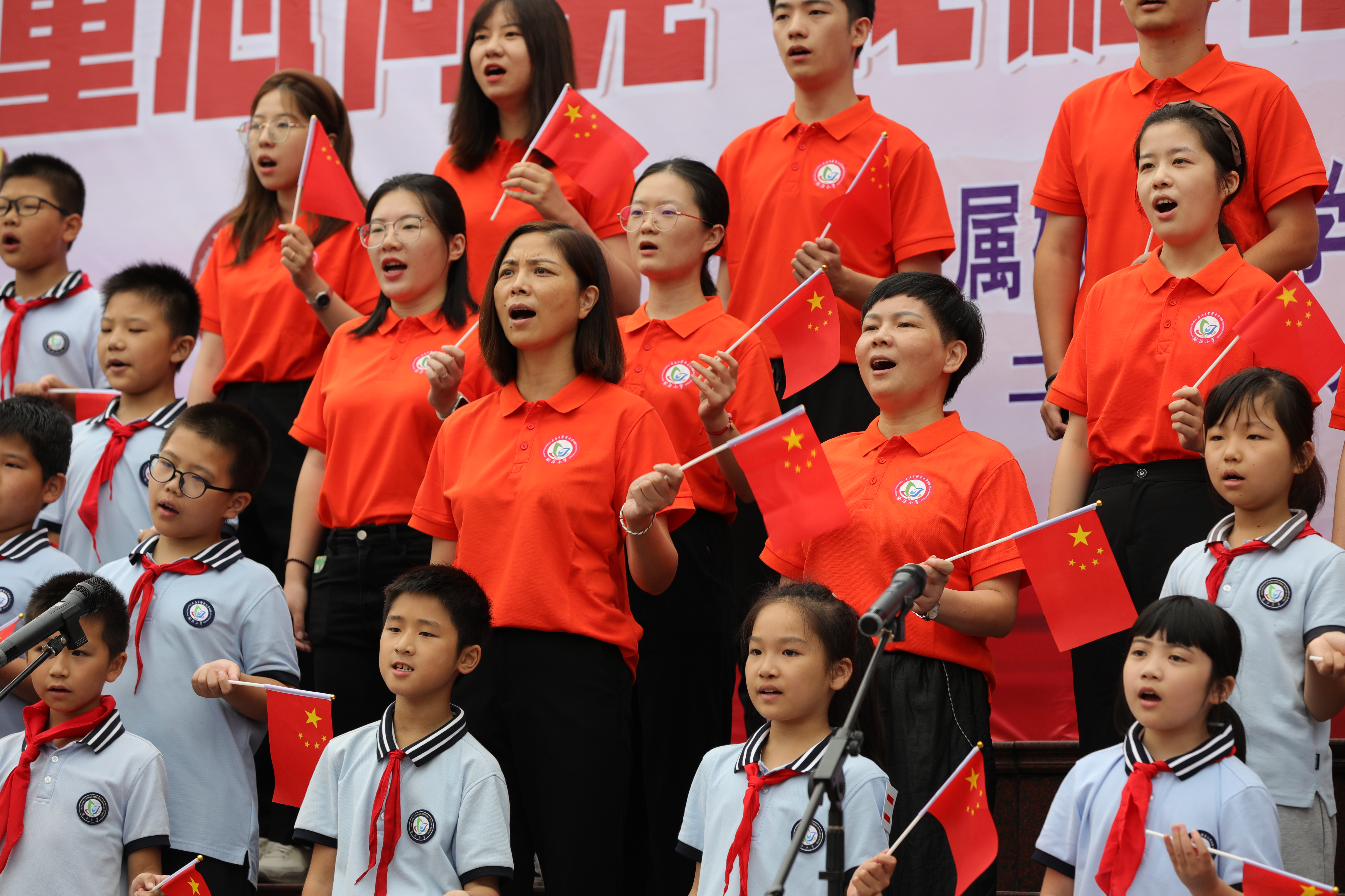8-2022年9月30日上午在学校大操场举行的庆祝新中国成立73周年主题升旗仪式上党支部书记唐丽辉带领师生同唱《歌唱祖国》.JPG