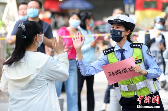 图为南京交警与考生击掌送祝福。泱波 摄