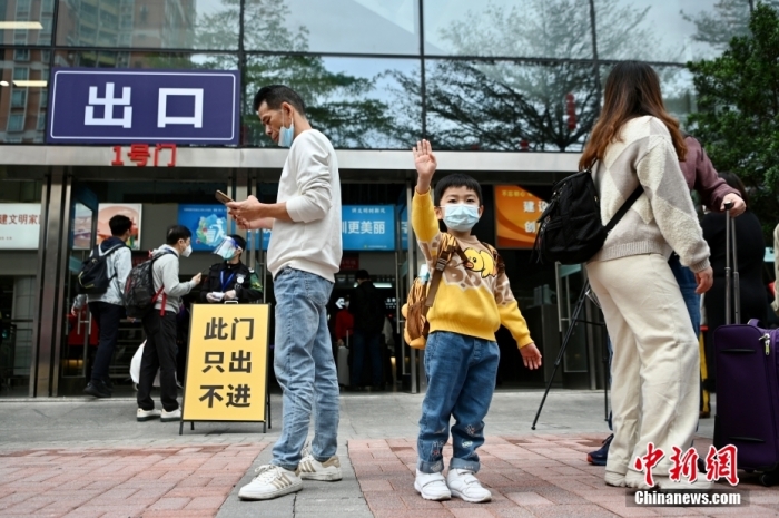 1月8日，香港与内地首日“通关”，旅客由落马洲口岸入境深圳，有前来迎接的亲友与香港旅客相拥。图为香港儿童踏出福田口岸向现场的人挥手。 中新社记者 李志华 摄